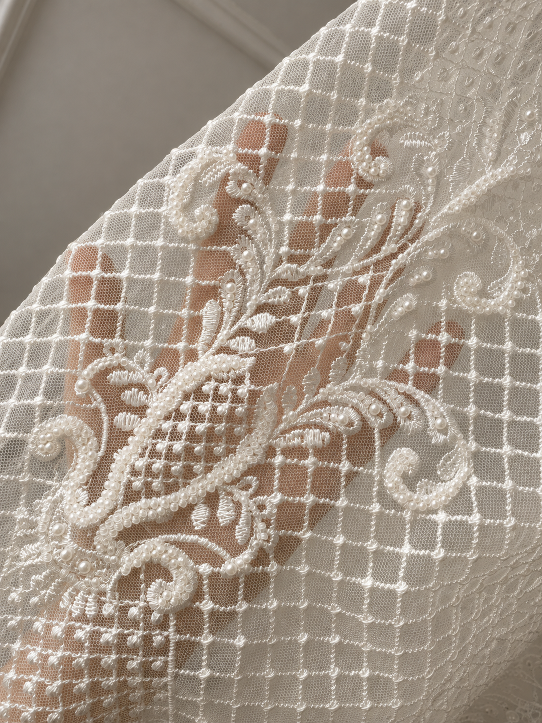 An elegant heirloom gown designed with timeless tradition in mind. Crafted from intricate lace, this gown features pearl and sequence embellishments throughout. It features delicate short sleeves, a softly structured bodice. The back is finished with delicate pearl buttons and a long mikado side belt that can be tied into a bow. The intricate lacework flows throughout the gown, creating beautiful texture and detail from every angle. 